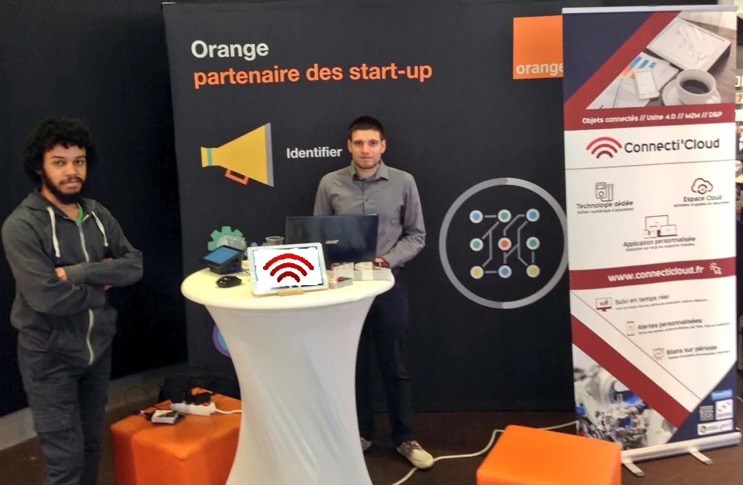 Erwann et Viktor sur le stand Connecti’Cloud aux Orange Days, autour d’une borne de démonstration